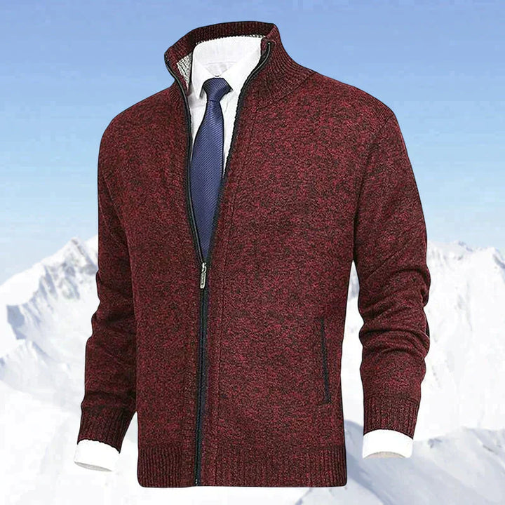 Bordeauxfarbener Herren-Strickjacke mit Reißverschluss, eleganter Stil, vor schneebedeckten Bergen.
