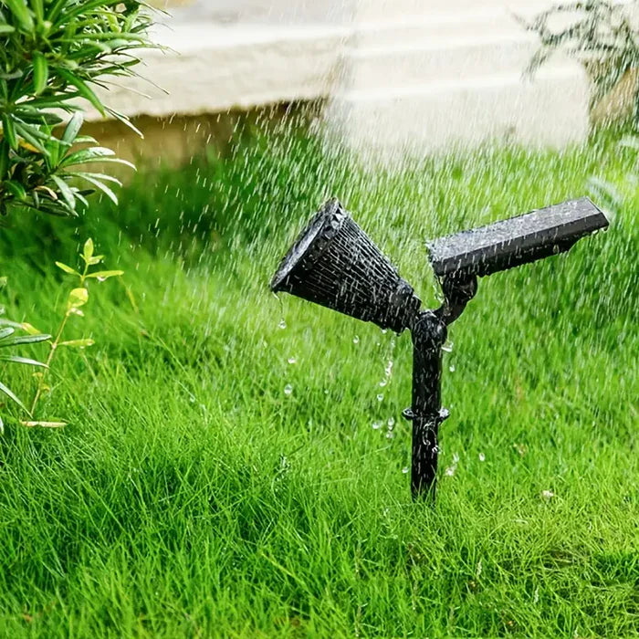 Schwarzer Gartenbewässerungssprinkler auf grünem Rasen, Wasserstrahl, automatische Bewässerung.