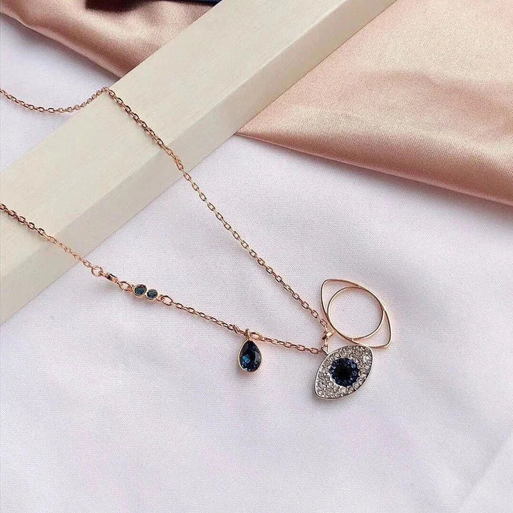 Roségoldene Halskette mit blauem Auge-Anhänger, Zirkonia-Steinen, elegantes Schmuckdesign.