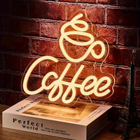 Leuchtendes LED-Neonschild "Coffee" auf Holztisch vor Ziegelwand, dekorative Beleuchtung.