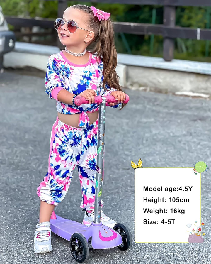 Mädchen auf lila Kinderroller, bunte Kleidung, Sonnenbrille, draußen, Freizeitaktivität.