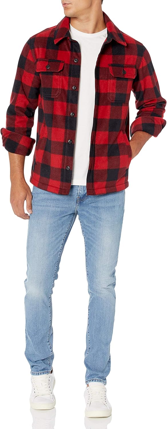 Mann in rotem kariertem Flanellhemd, blauer Jeans und weißen Sneakers, lässige Mode.