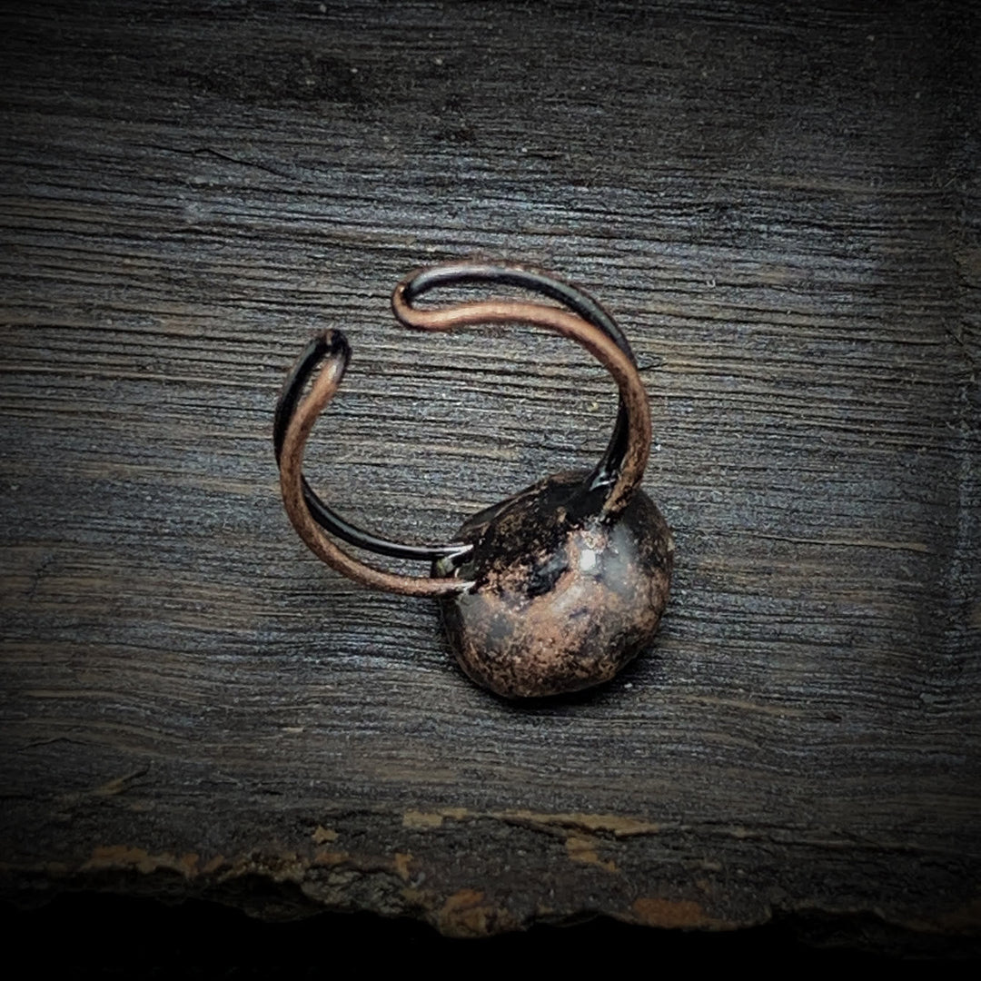 Rustikaler, handgefertigter Kupferring auf Holzoberfläche, Vintage-Schmuck, Unikat.