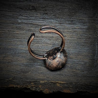 Rustikaler, handgefertigter Kupferring auf Holzoberfläche, Vintage-Schmuck, Unikat.