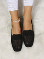 Schwarze Damen-Loafer aus Strick, quadratische Spitze, elegant, bequem, auf weißem Teppich.