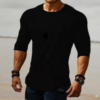 Mann in schwarzem T-Shirt, muskulös, am Strand, modisch, lässig, Herrenbekleidung.