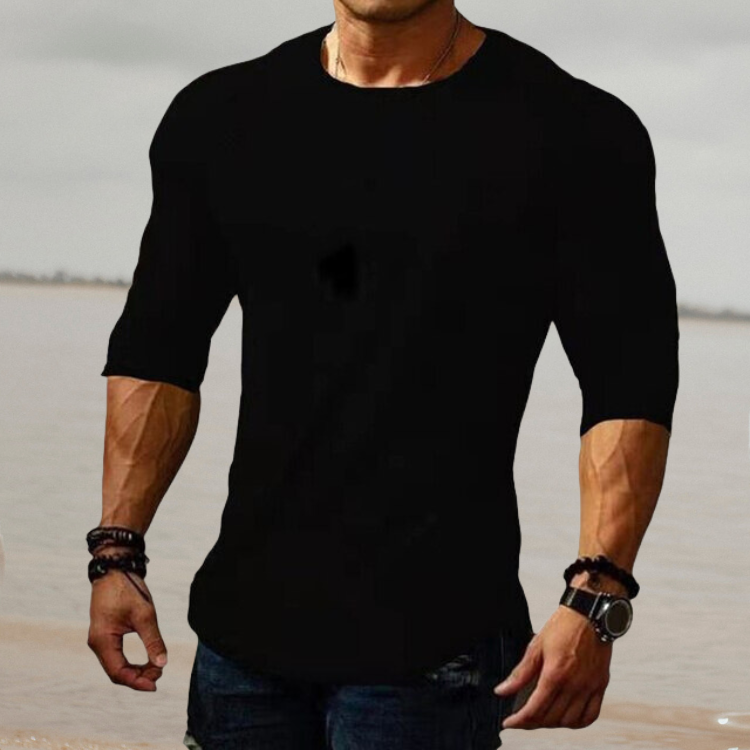 Mann in schwarzem T-Shirt, muskulös, am Strand, modisch, lässig, Herrenbekleidung.