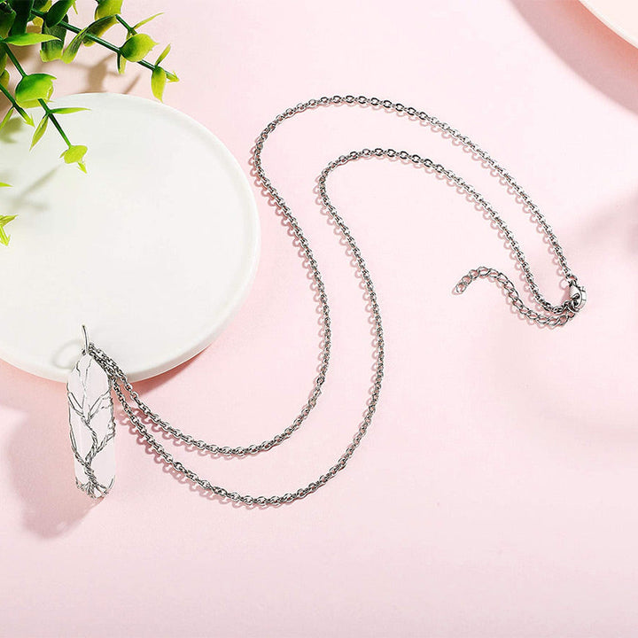 Silberne Halskette mit Blattanhänger auf rosa Hintergrund, eleganter Schmuck für Damen.