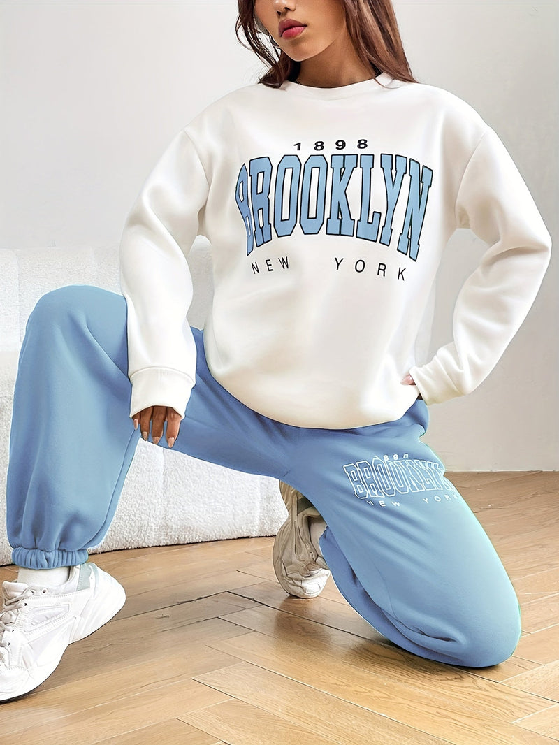 Frau in weißem Brooklyn-Pullover und blauer Jogginghose, modisch, sportlich, lässig.