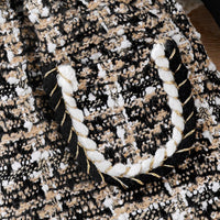 Schwarz-weiße Tweed-Tasche mit geflochtenem Griff, elegantes Design, Damenmode-Accessoire.