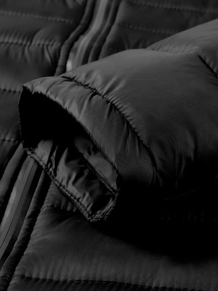 Schwarze Daunenjacke, gesteppter Stoff, Reißverschluss, Wintermode, isolierte Oberbekleidung.