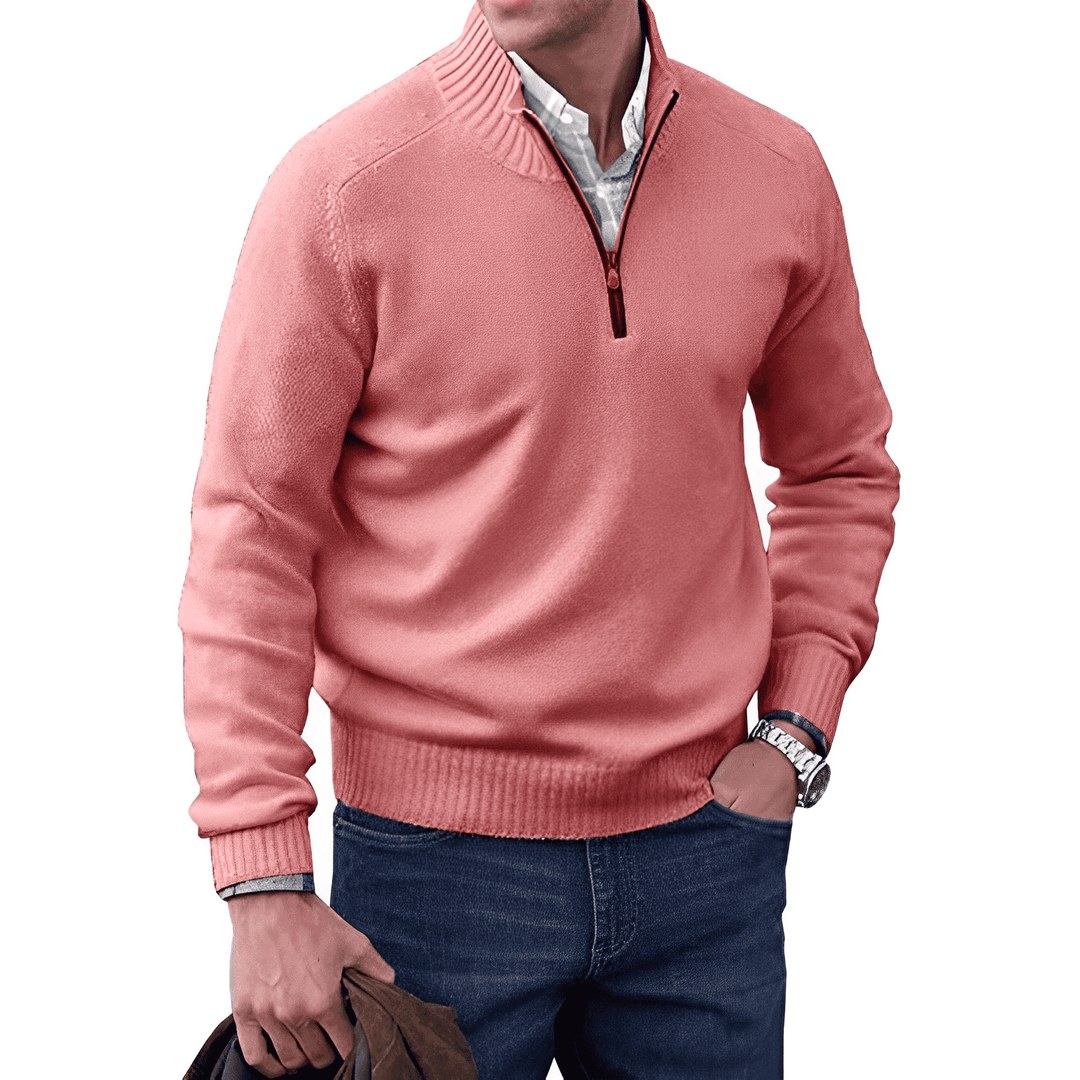 Mann in rosa Pullover mit Reißverschluss, blaue Jeans, weißes Hemd, lässiger Stil.