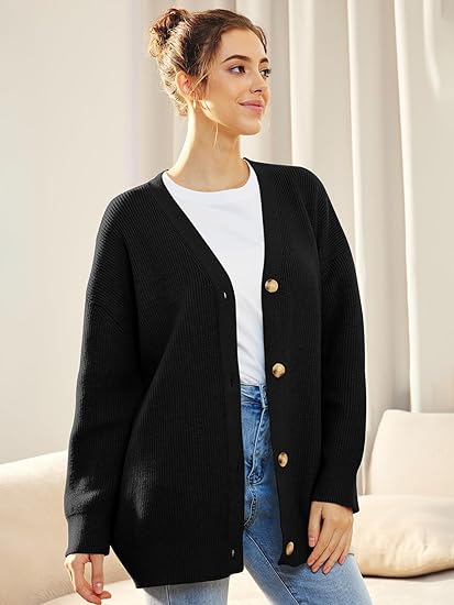 Frau trägt schwarzen Strick-Cardigan mit Knöpfen, weißes T-Shirt, blaue Jeans, lässiger Look.