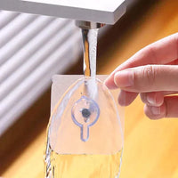 Hand hält transparenten Wasserfilter unter Wasserhahn, Küche, Wasserreinigung, Kunststoff.