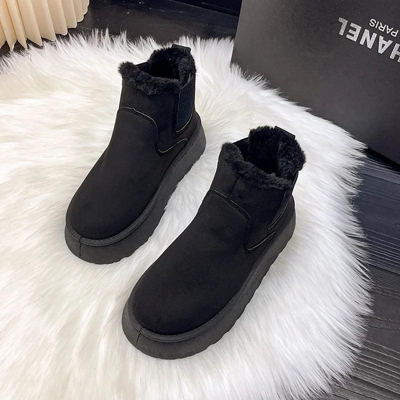 Schwarze Ankle Boots mit Fellfutter auf weißem Teppich, warme Winterschuhe, Damenmode.