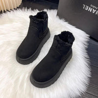 Schwarze Ankle Boots mit Fellfutter auf weißem Teppich, warme Winterschuhe, Damenmode.