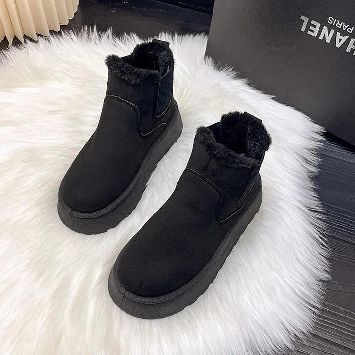 Schwarze Ankle Boots mit Fellfutter auf weißem Teppich, warme Winterschuhe, Damenmode.