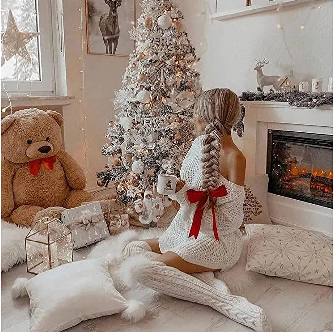 Frau in weißen Stricksocken vor Weihnachtsbaum, gemütliches Wohnzimmer, Winterdekoration.