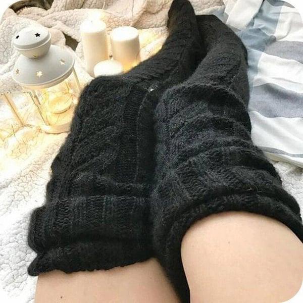 Schwarze, hochgestrickte Wollsocken auf Bett, gemütlich, warm, ideal für Winter, Luca Norelli.