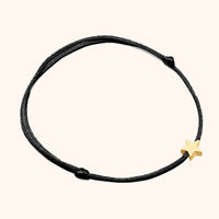 Schwarzes Armband mit goldfarbenem Sternanhänger, minimalistisches Schmuckdesign.