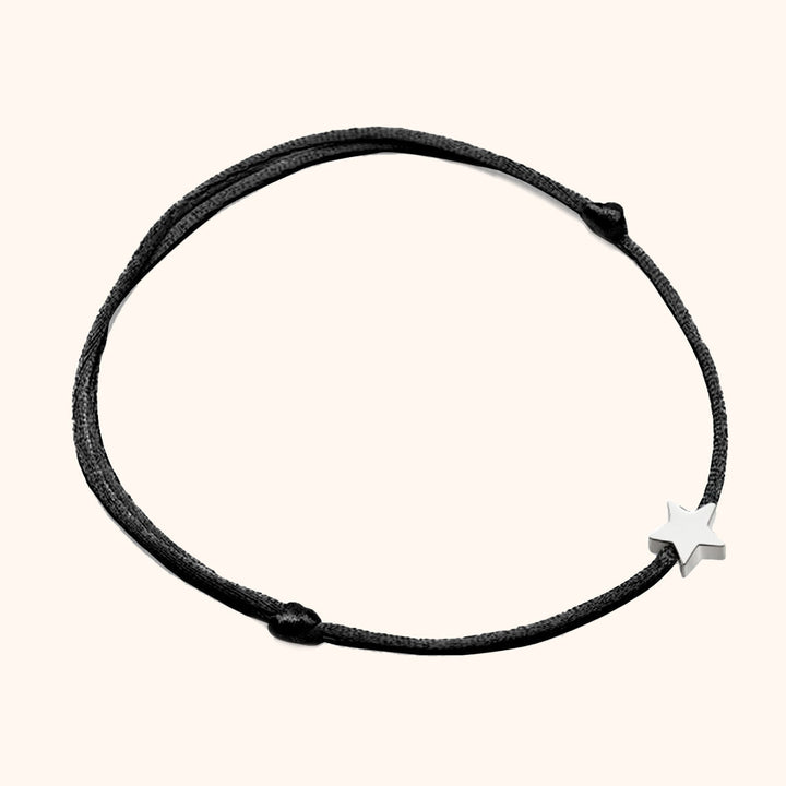 Schwarzes Armband mit silbernem Sternanhänger, verstellbar, modisches Accessoire.