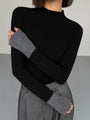 Frau in schwarzem Rollkragenpullover und grauen Handschuhen, modisch, elegant, Herbstmode.