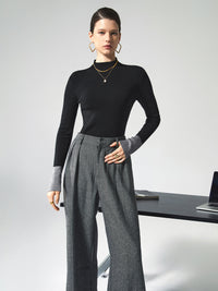 Frau in schwarzem Pullover und grauer Hose, Büro-Outfit, moderne Mode, eleganter Stil.