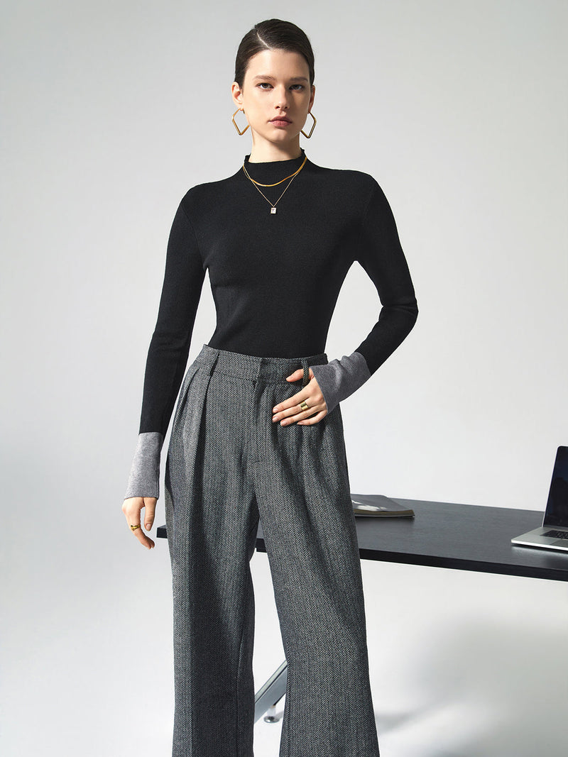 Frau in schwarzem Pullover und grauer Hose, Büro-Outfit, moderne Mode, eleganter Stil.