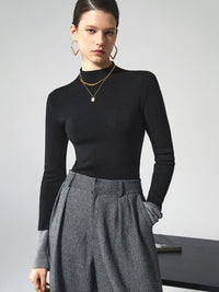 Frau in schwarzem Rollkragenpullover und grauer Hose, elegantes Outfit, Modefotografie.