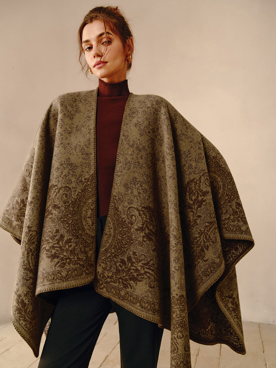 Frau trägt braunen Poncho mit floralem Muster, elegantes Herbstoutfit, Mode für Damen.