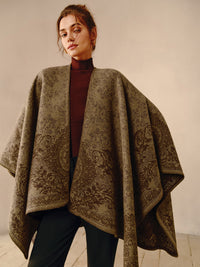 Frau trägt braunen Poncho mit floralem Muster, elegantes Herbstoutfit, Mode für Damen.