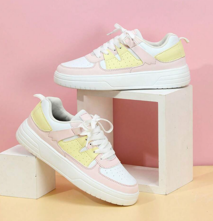 Weiße und rosa Sneaker mit gelben Akzenten, Damen, auf rosa Hintergrund, modisch, bequem.