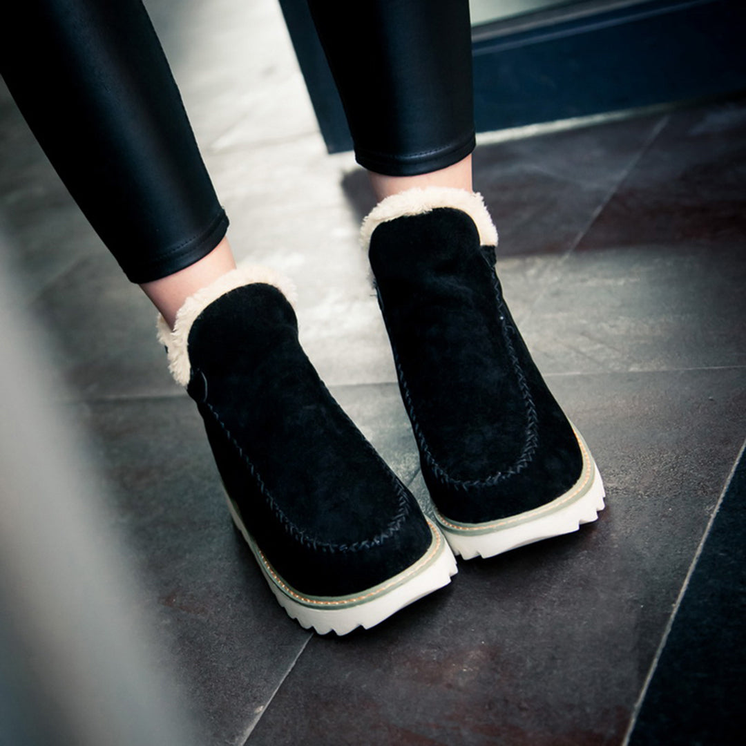 Schwarze Damen-Winterstiefel aus Wildleder mit weißem Fellfutter und dicker Sohle.