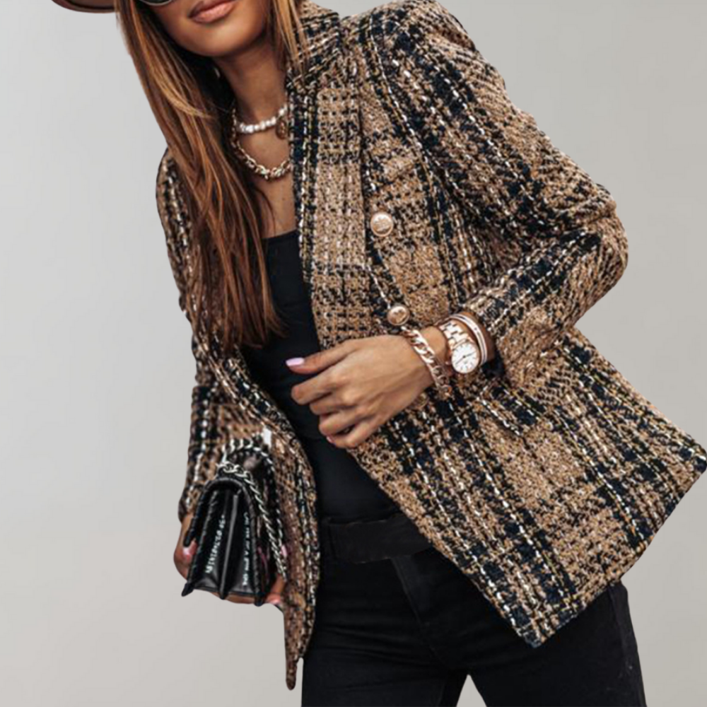 Frau in kariertem Tweed-Blazer, schwarz-gold, mit Uhr und Tasche, modisch elegant.