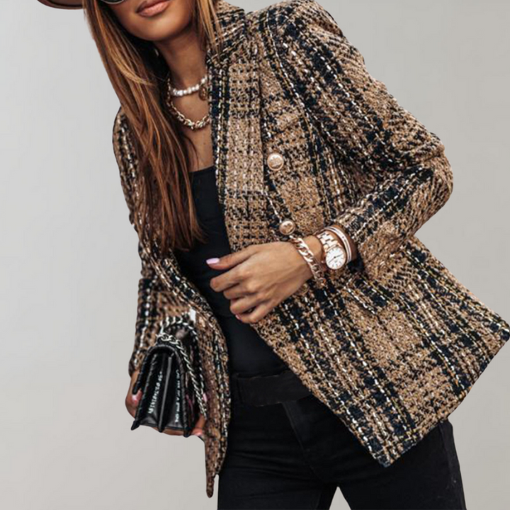 Frau in kariertem Tweed-Blazer, schwarz-gold, mit Uhr und Tasche, modisch elegant.