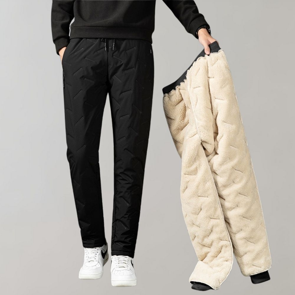 Mann in schwarzer Stepphose hält beige Fleecehose, Wintermode, Herrenbekleidung.