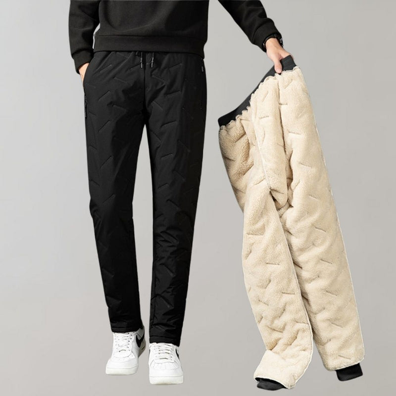 Mann in schwarzer Stepphose hält beige Fleecehose, Wintermode, Herrenbekleidung.