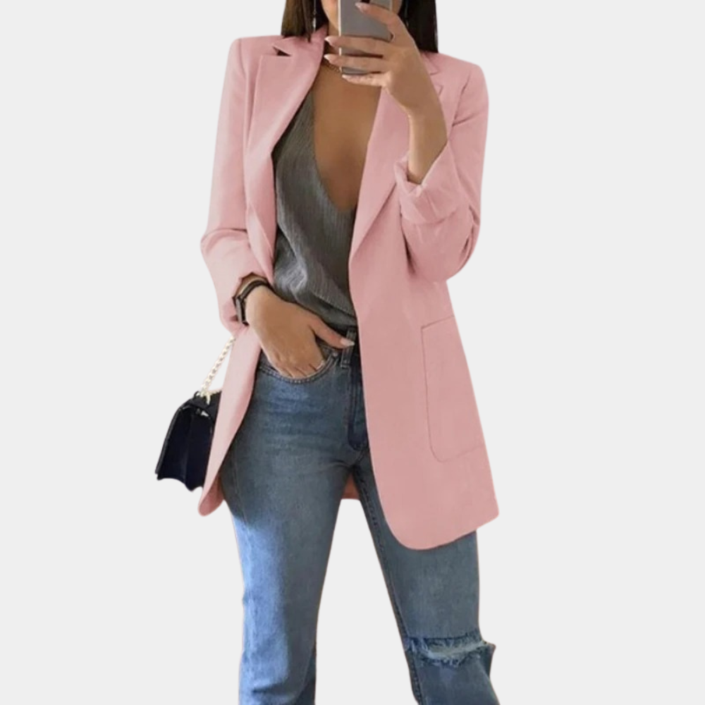 Frau in rosa Blazer, grauem Top, Jeans; modischer Damenblazer, eleganter Look.