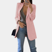 Frau in rosa Blazer, grauem Top, Jeans; modischer Damenblazer, eleganter Look.