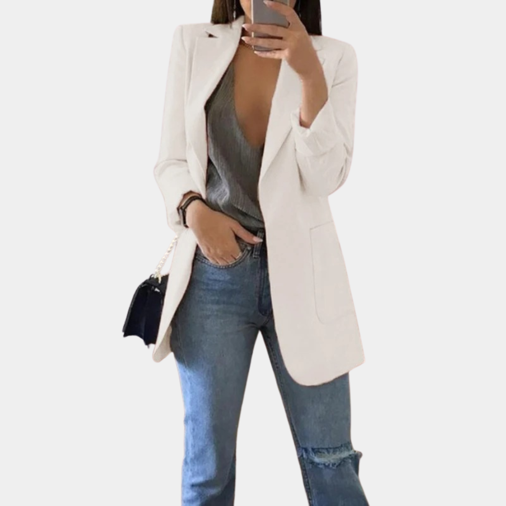 Frau in weißem Blazer, grauem Top und blauer Jeans, modisch, elegant, Streetwear.