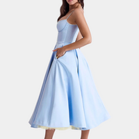 Frau in hellblauem, ärmellosem Kleid mit weitem Rock, elegantes Abendkleid, Seitenansicht.