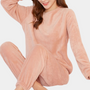 Frau in rosa Fleece-Pyjama-Set, gemütlich, langärmelig, für Damen, bequemes Schlafanzug-Outfit.
