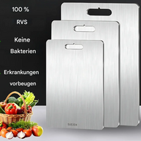 Drei silberne Edelstahl-Schneidebretter, antibakteriell, mit Griff, Gemüsekorb im Hintergrund.