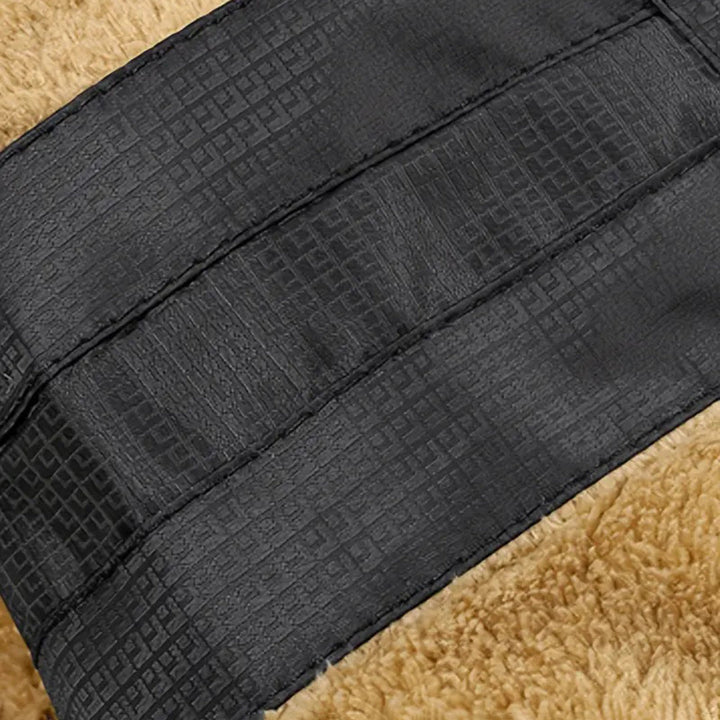 Schwarzer, texturierter Ledergürtel auf beigem Hintergrund, modisches Accessoire.