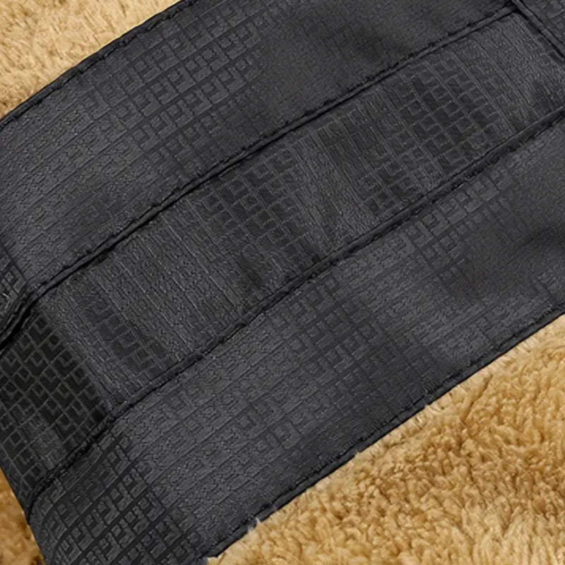 Schwarzer, texturierter Ledergürtel auf beigem Hintergrund, modisches Accessoire.