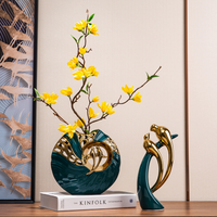 Grüne Keramikvase mit gelben Blumen und goldenen Vögeln, dekorative Wohnaccessoires.