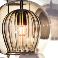 Moderne Hängelampe aus Glas mit Messingdetails, warmes Licht, elegantes Design, Wohnzimmerbeleuchtung.