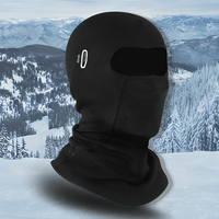 Schwarze Fleece-Sturmhaube für Wintersport, isolierend, atmungsaktiv, vor verschneiter Berglandschaft.