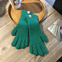 Grüne Strickhandschuhe aus Wolle auf Holztisch, ideal für Wintermode und Outdoor-Aktivitäten.