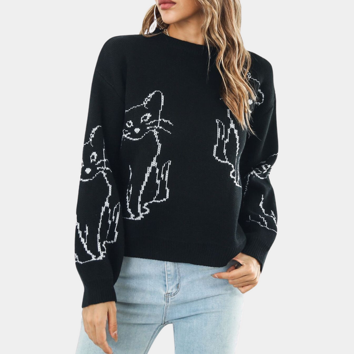 Frau trägt schwarzen Pullover mit Katzenmotiv, lässig, modisch, Damenmode, Strick, Herbst.
